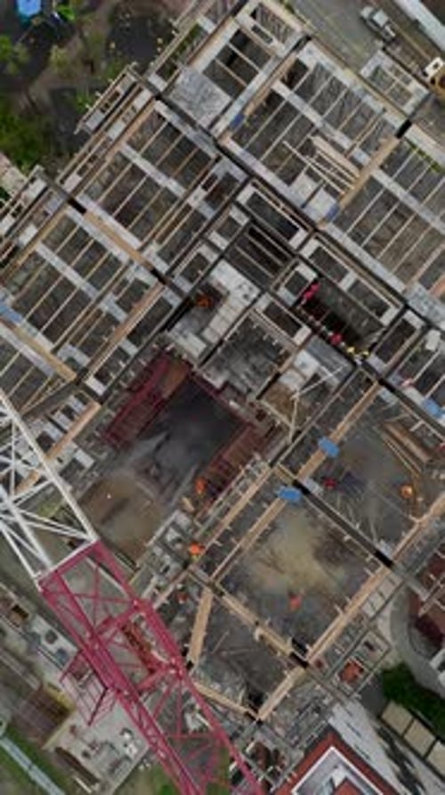 Vertical Video of Tower Crane Assisting HighRise Wall Construction
