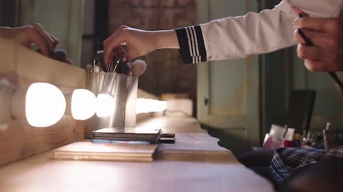 Choosing Makeup Brushes at Vanity Table