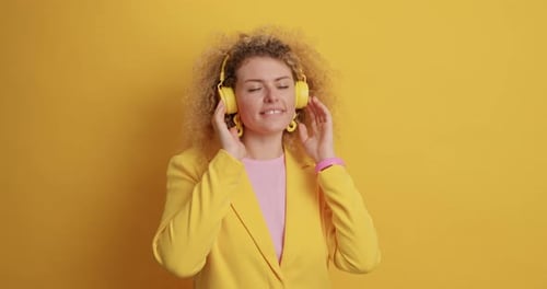 Woman Listening to Music on Headphones in Studio