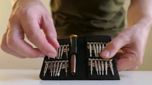 Mann bereitet Präzisionsschraubendreher-Set vor, Nahaufnahme