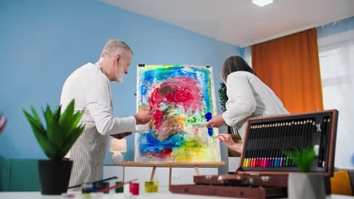 Senior Couple Painting Together on a Colorful Canvas