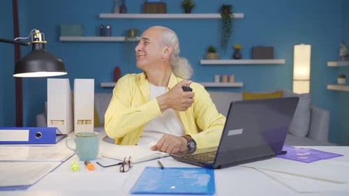 Home office worker sprays perfume on old man.