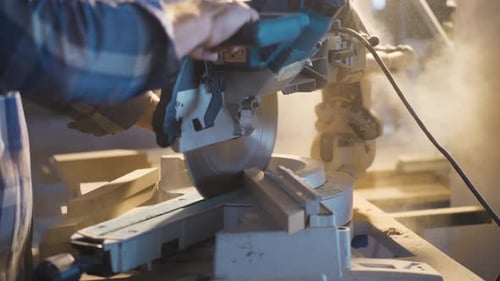 Carpenter Cutting Wood with Chop Saw in Workshop