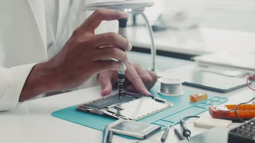 Hände eines Ingenieurs beim Abschrauben des Details mit einem Schraubenzieher
