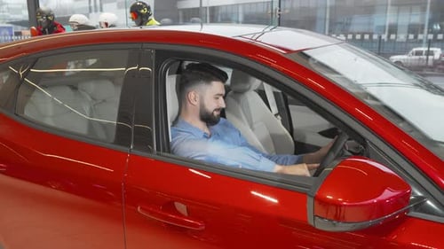 Confident Young Man Smiling in a Sleek New Car at the Dealership