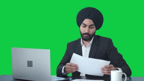 Sikh Indian businessman working on Laptop Green screen