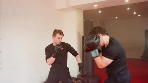 MMA Fighter Sparring Inside Gym Wearing Black Gloves and Sportswear