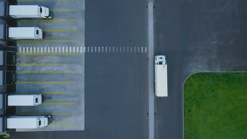 Luftaufnahme eines Industriehauses, eines Lagergebäudes/einer Ladefläche, auf der sich viele Lkw befinden
