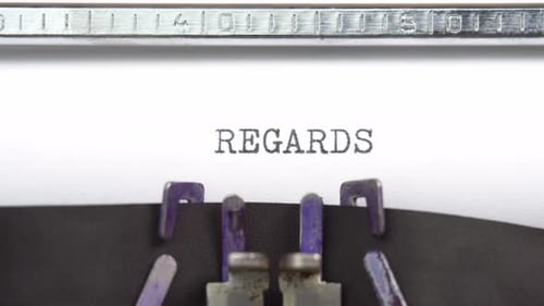 Regards word closeup being typing and centered on a sheet of paper on old vintage typewriter mech