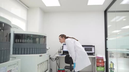 Woman in Lab Coat Examining Medical Equipment