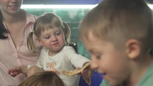 Mother and Children Eating Pizza Together Indoors