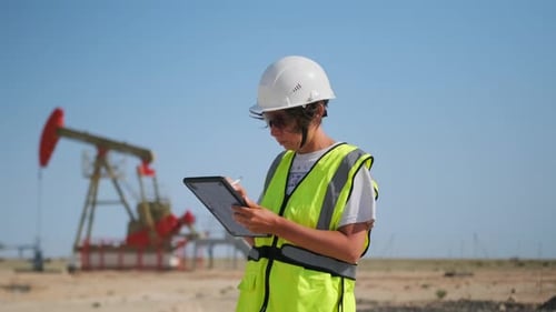 Feldtechniker zeichnet Messungen im Freien auf — Arbeiter bewertet Maschinenstatus im Sonnenfeld
