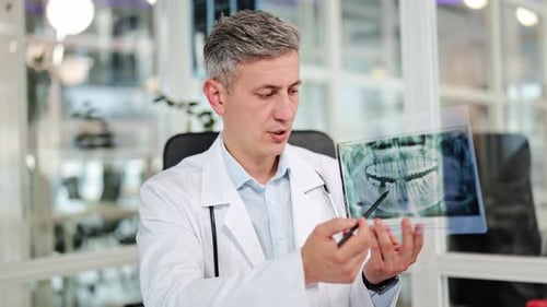 Professional Dentist Explaining Dental Xray to Patient in Modern Medical Clinic