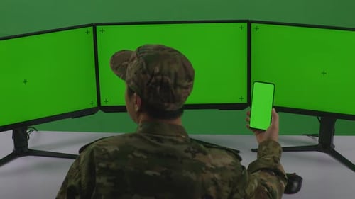 Asian Man Soldier Using Mobile Phone And Multiple Monitor With Mock Up Green Screen In Green Screen