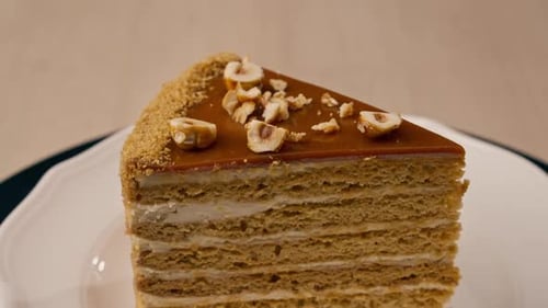 A dessert close-up of a piece of delicious honey cake lying on a white plate in Italian restaurant