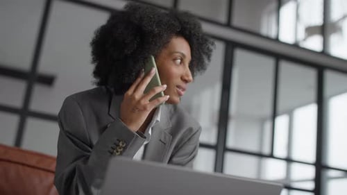 Smiling Businesswoman Talking on Smartphone in Office