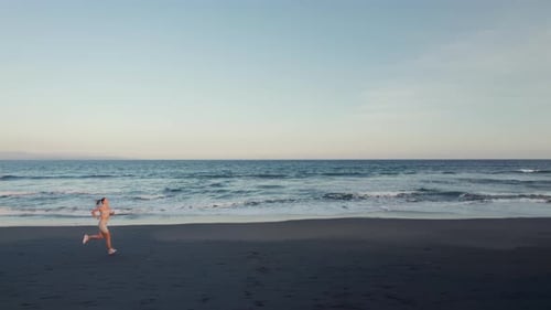 Young Woman Athlete Running on Beach Exercising Female Runner Sprinting Training in Evening Seaside