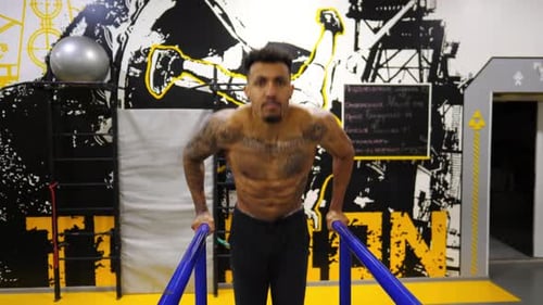 Strong African Man Doing Push Ups on Parallel Bars at Sport Club Muscular Afro American Sportsman