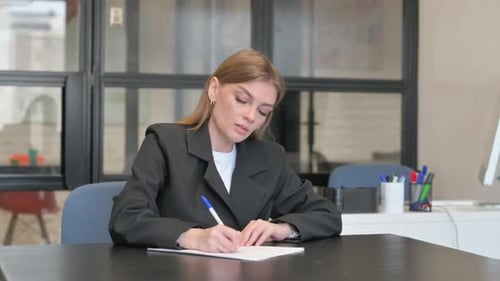Young Businesswoman Writing a Letter in Office