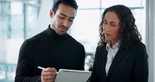 Business Professionals Reviewing Tablet in Modern Office