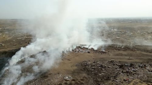 Aerial view of landfill with burning trash piles