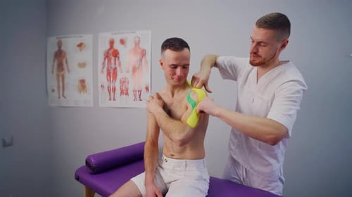 Man Receiving Kinesiology Tape Treatment on Shoulder