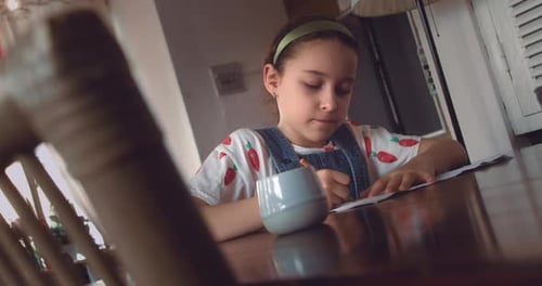 Porträt eines kleinen Mädchens, niedliches Grundschulkind von 9-10 Jahren, zu Hause, sitzt entspannt im Haus