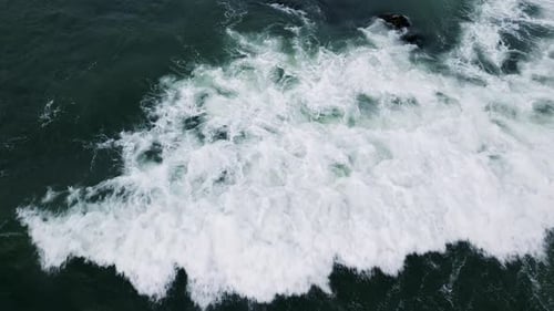 Aerial View of Ocean Waves Crashing and Creating White Foam on Deep Green Water