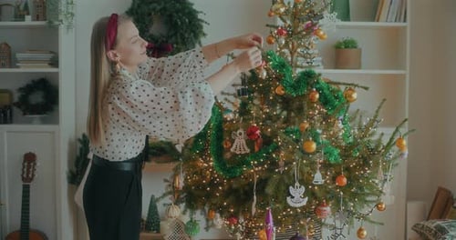 Woman Decorating Christmas Tree at Home