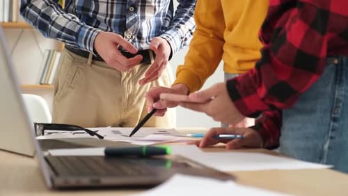 Team Collaborate on Project Using Documents and Laptop