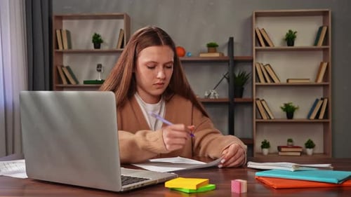 Young Teenage Girl Studying at Home Girl Sits at Desk with Laptop and Books Doing Homework Writing