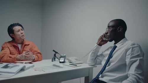 Police Officer Making a Phone Call During Interrogation