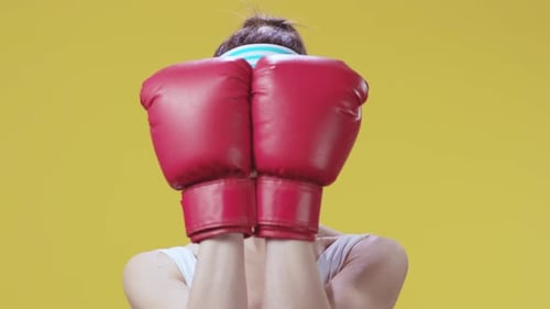 Woman with Boxing Gloves on Yellow Background
