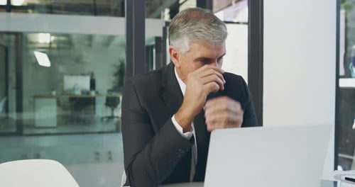 4k video footage of a mature businessman looking stressed out while working in his office