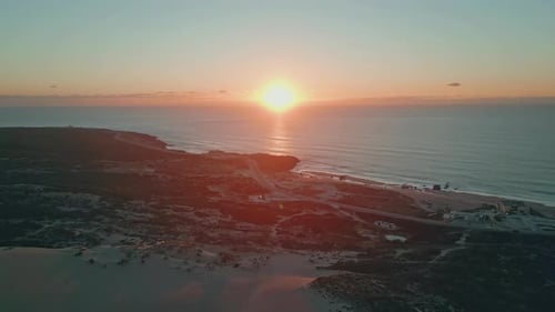 Coucher de soleil aérien, lueur de l'océan dans une soirée sereine, le crépuscule descend sur une côte tranquille