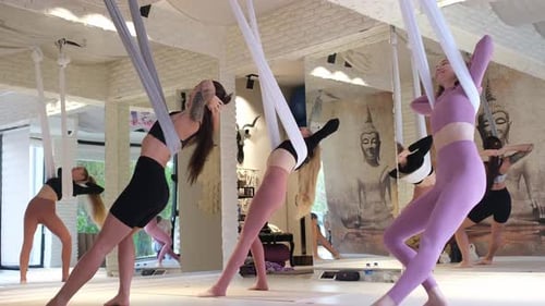 Women Practicing Aerial Yoga in Studio
