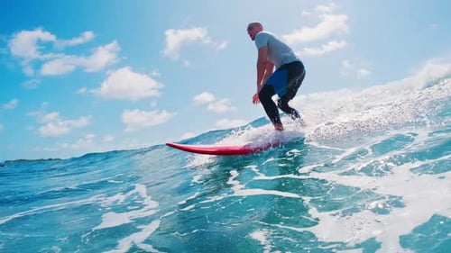 Surfista masculino surfa na onda. Homem surfa a onda azul perfeita durante um dia ensolarado nas Maldivas