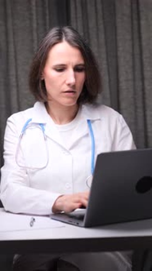 Female Doctor Works on Laptop in Office