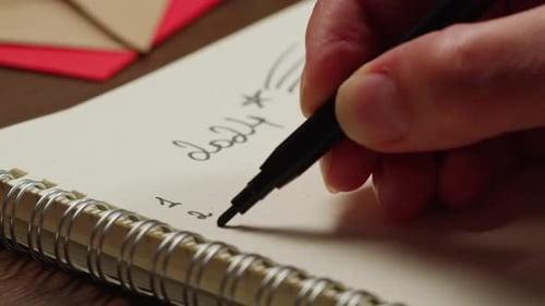 Hads Writting Some Goals Purposes on List on Wooden Desk Surrounded By Christmas Decorations and