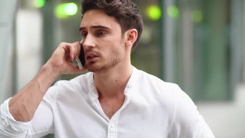 Focused young man talking on phone in city