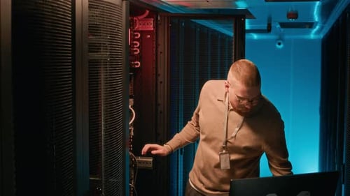 Man Analyzes Cables in a Data Center