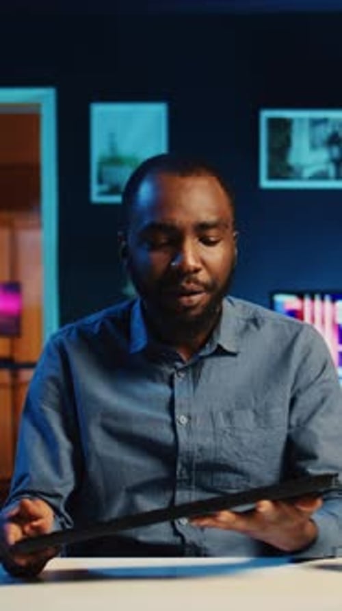 Young Adult Reviewing Black Keyboard Device at Desk