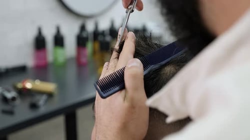 Barber Cuts Hair with Scissors and Comb