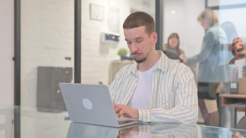 Creative Young Man Looking at Camera while Working in Office