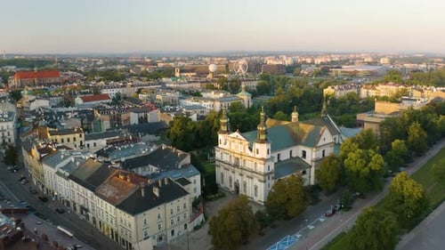 Drone Flies Above Historic Buildings in Krakow, Poland at Sunrise in Summertime