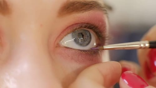Makeup Artist Applying Eye Shadow Makeup to Model's Eye Close Up View Smoky Eyes Left View Slow