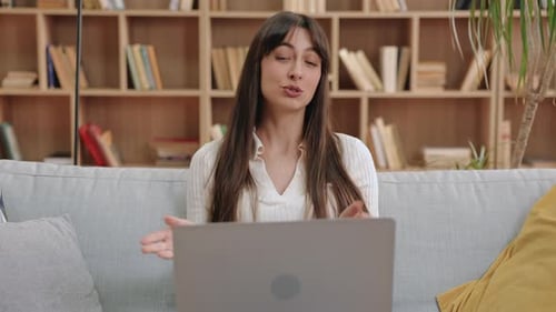 Woman Talking in Front of Laptop on Couch