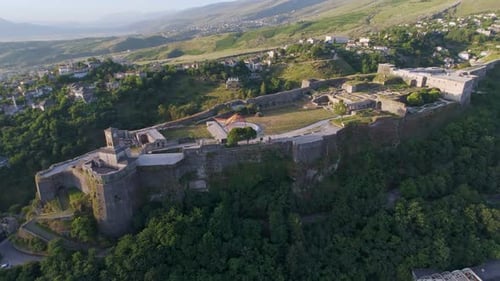 Castle of Gjirokastra in Drino Valley, warm morning light, high angle drone orbit