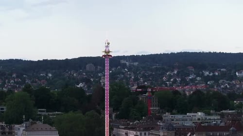 Orbit Shot Around Tall Tower with Neon Lights at Twilight Adrenaline Attraction Towering High Above