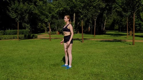 Woman Doing Squats in Urban Park on Sunny Day